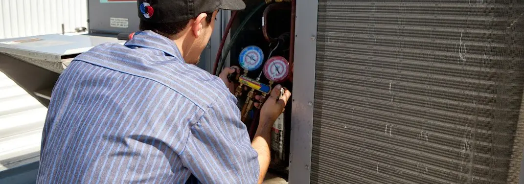 HVAC technician servicing a condenser unit in West Cocalico